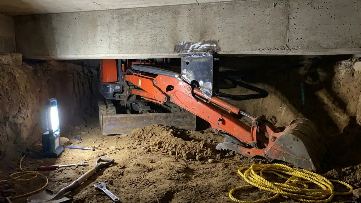 Editorial image: Modified excavator wedged in crawl space - OSHA Fines Texas Contractor, Staffing Firm Over Fatal Crawl-Space Death