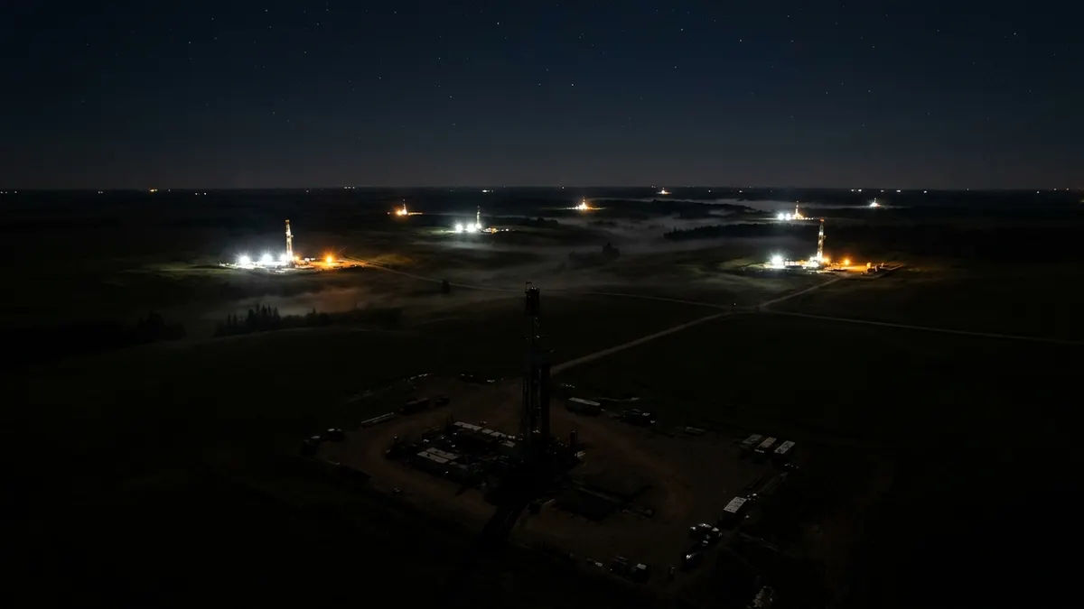 Editorial image: aerial night view, scattered rig lights - Western Canada Rig Count Eases to 206 as Oil-Directed Drilling Pulls Back