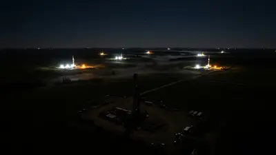 Editorial image: aerial night view, scattered rig lights - Western Canada Rig Count Eases to 206 as Oil-Directed Drilling Pulls Back