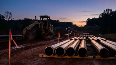 Editorial image: Pipeline corridor staged at dusk - FERC Clears $1.7B Kinder Morgan Pipeline Across Mississippi, Setting Up Construction Bid Rush