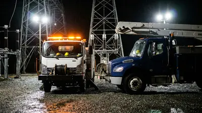 Editorial image: Two utility trucks, substation night - Emera to Acquire Canadian Utilities in $72B Merger of Equals